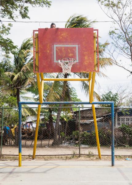 A local climbs a basketball goal. Photo: Brian Mackin
